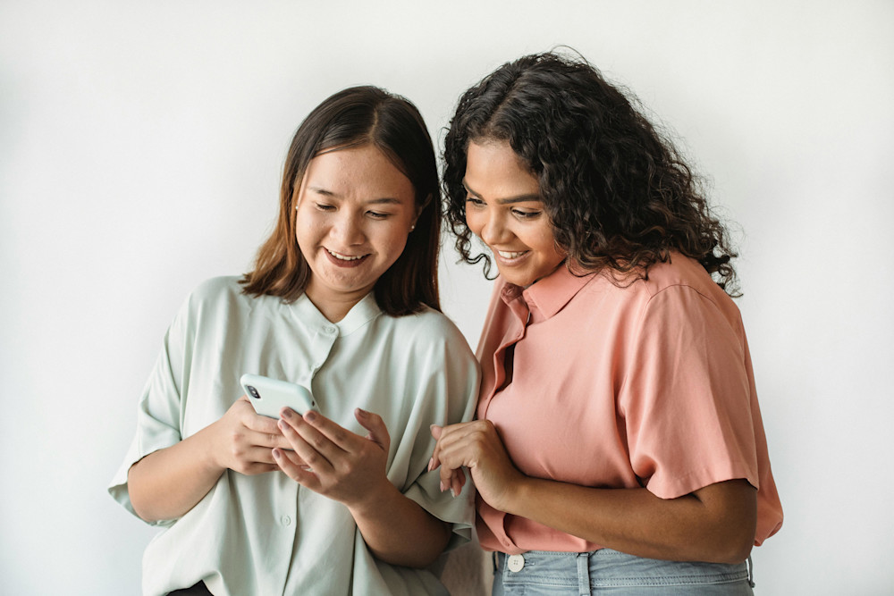 Two Women Looking at Phone - Trust